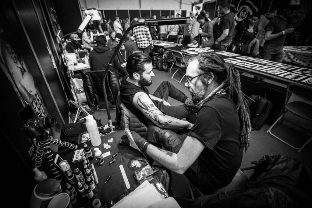 Tattoo artist working on a custom tattoo during a tattoo convention