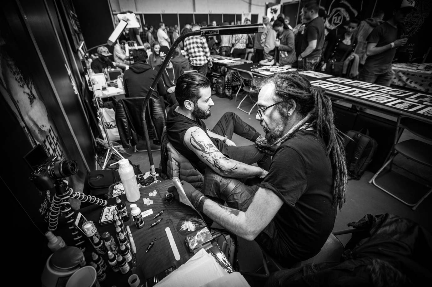 Tattoo artist working on a custom tattoo during a tattoo convention